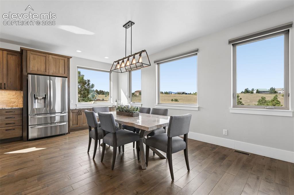 Image 12 of 50: Hardwood flooring, wood cabinetry, stainless steel refrigerator, recessed l