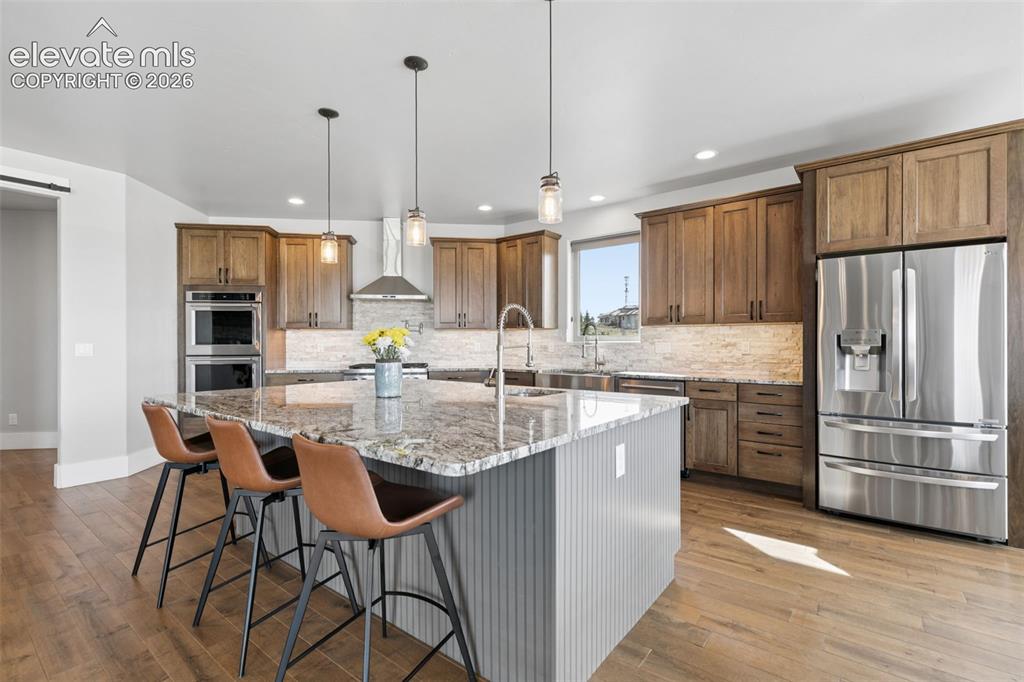 Image 14 of 50: Gourmet kitchen featuring wood-finish cabinetry, stainless steel appliances