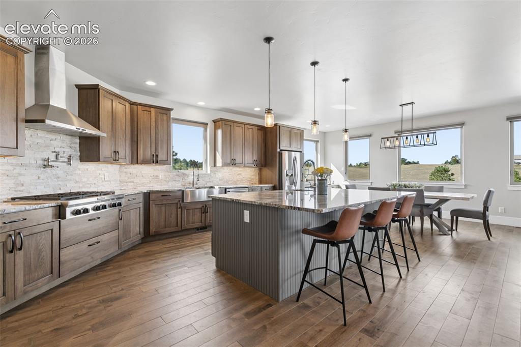 Image 15 of 50: Gourmet kitchen featuring wood-finish cabinetry, stainless steel appliances