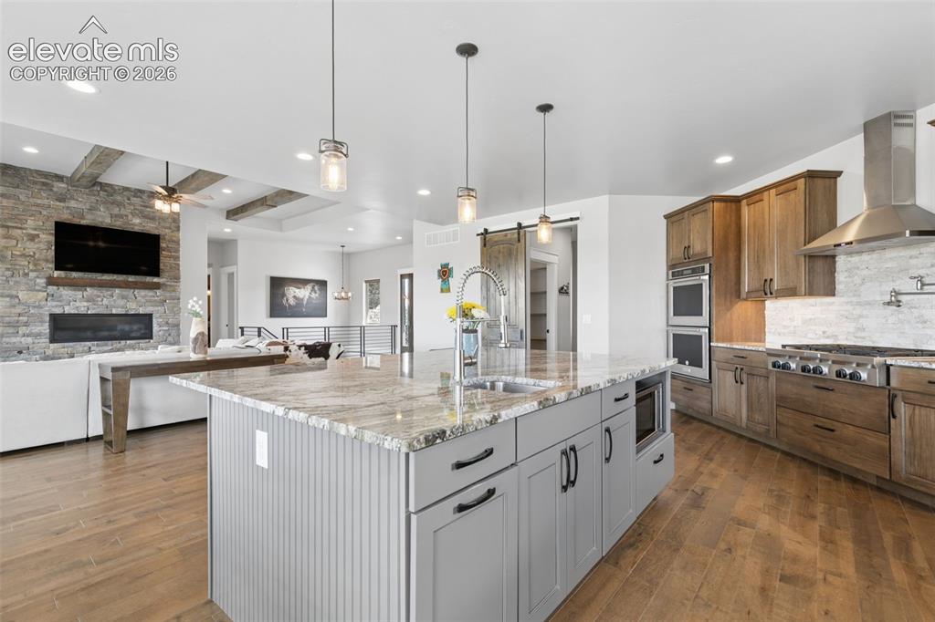 Image 16 of 50: Gourmet kitchen with double ovens, a gas range, and a large central island
