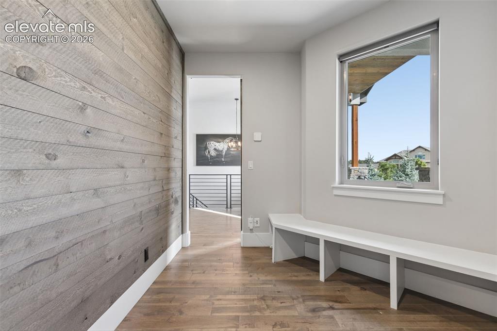 Image 20 of 50: Wood-finish flooring, accent wall with horizontal wood planks, built-in win