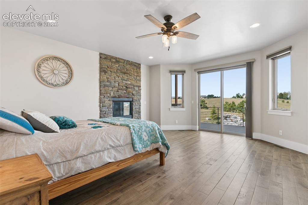 Image 22 of 50: Stone-clad fireplace feature, recessed lighting, wood-finish flooring, ceil
