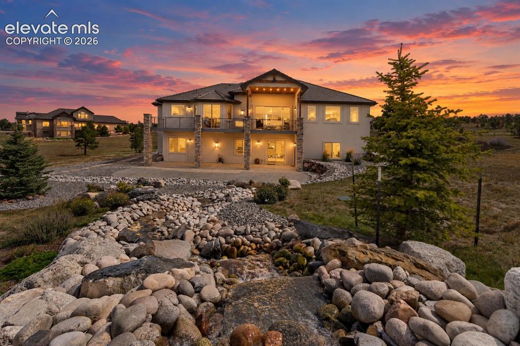 Image 3 of 50: Multi-story exterior with stone column accents and multiple balconies