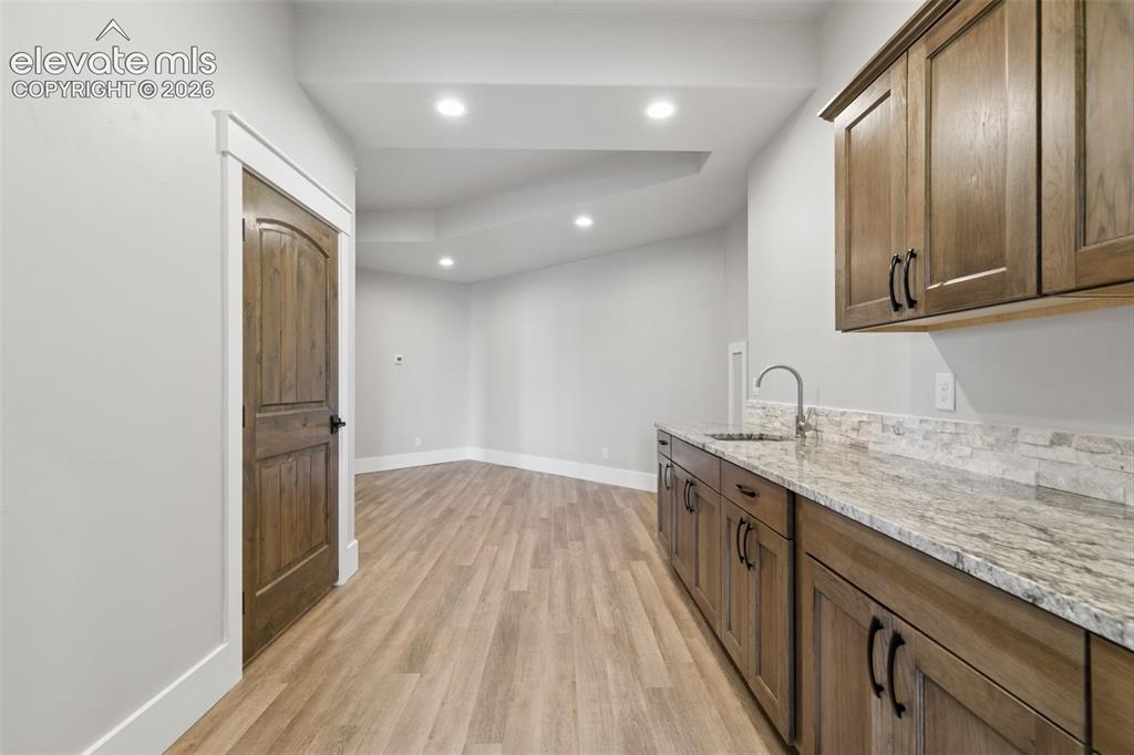 Image 34 of 50: Wood-finish flooring throughout, featuring recessed lighting and a built-in