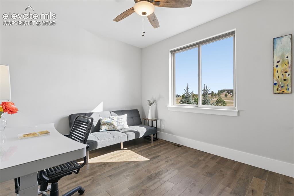 Image 35 of 50: Wood-finish flooring, light-toned walls, and a ceiling fan with integrated 