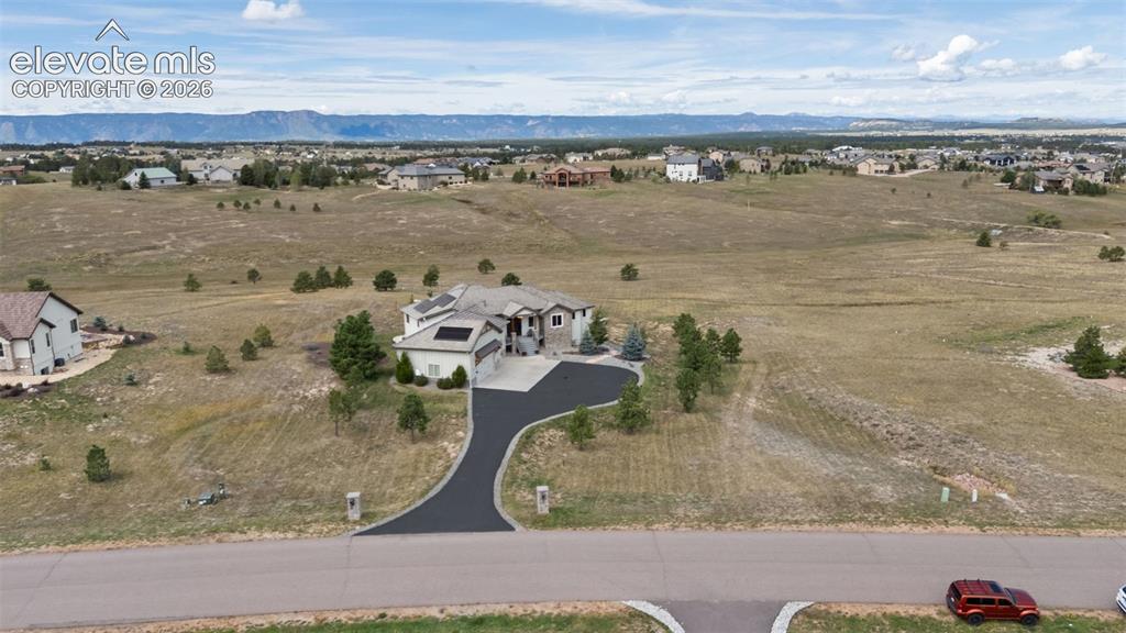 Image 48 of 50: Expansive suburban property with a paved driveway, attached garage, and mou