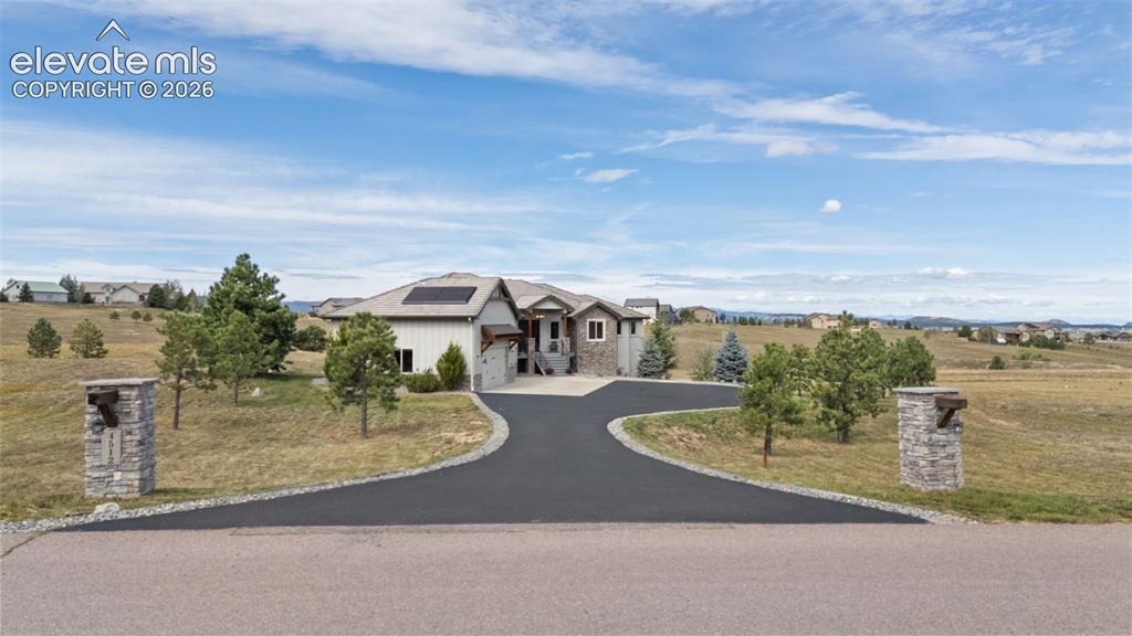 Image 49 of 50: Spacious property featuring a paved circular driveway, stone-clad entry pil