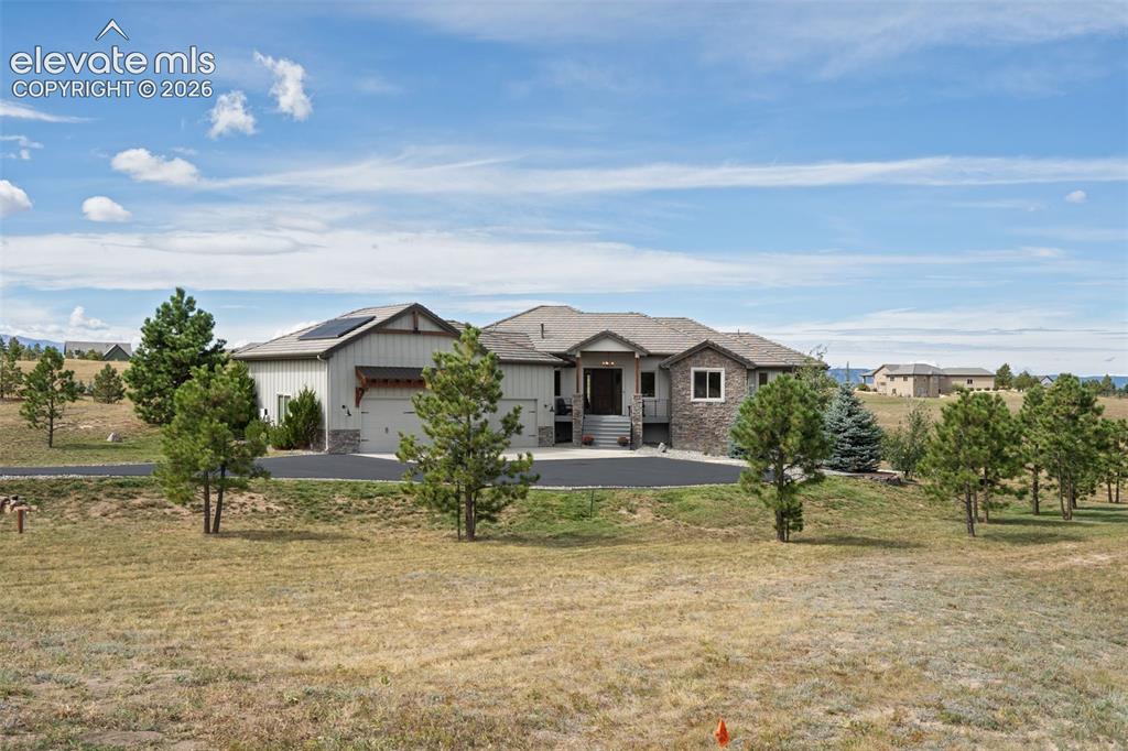 Image 50 of 50: Expansive property featuring a stone and siding exterior, multi-car garage,