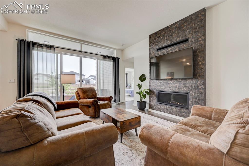 Image 3 of 48: Living room featuring a large fireplace and wood finished floors