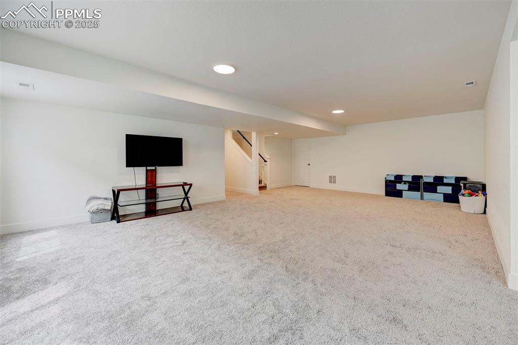 Image 34 of 48: Finished below grade area featuring baseboards, carpet flooring, stairway,