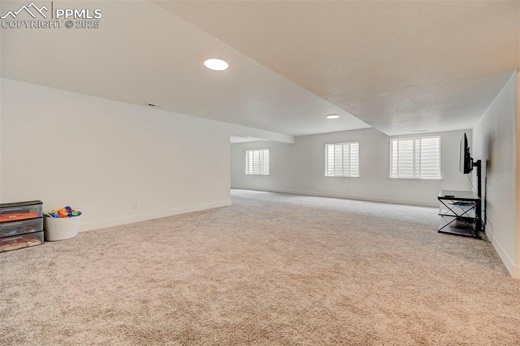 Image 35 of 48: Unfurnished living room with carpet flooring, baseboards, and recessed ligh