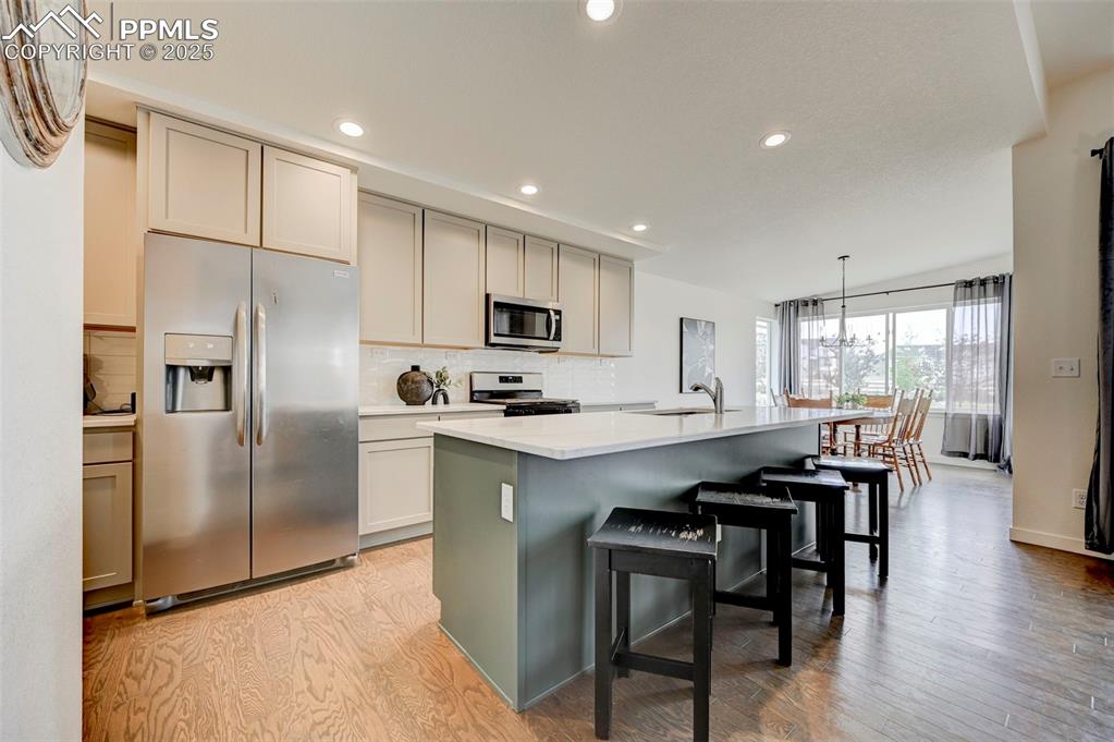 Image 5 of 48: Kitchen featuring stainless steel appliances, a sink, backsplash, recessed