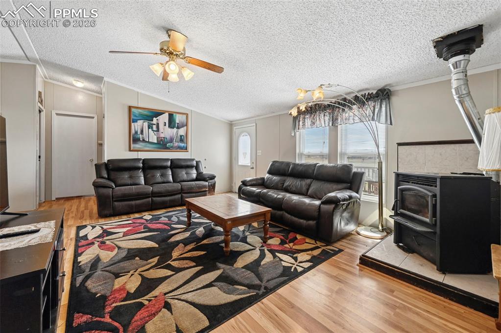Image 9 of 47: LivingRoom Boast Wood floors and Pellet Stove.