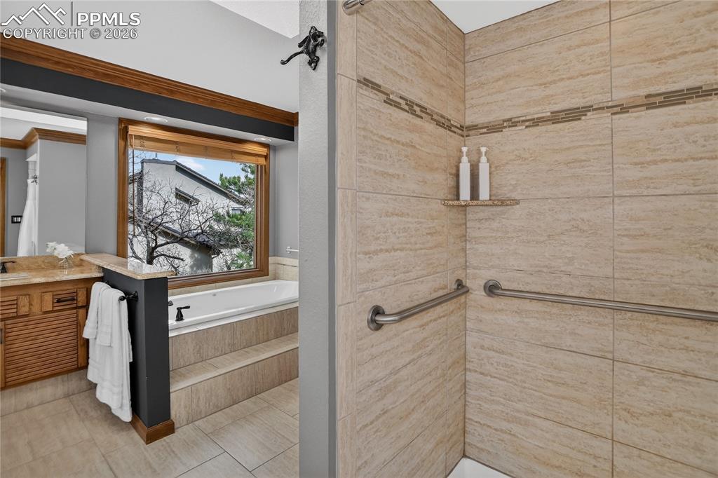 Image 21 of 42: Primary soaking tub & tiled shower