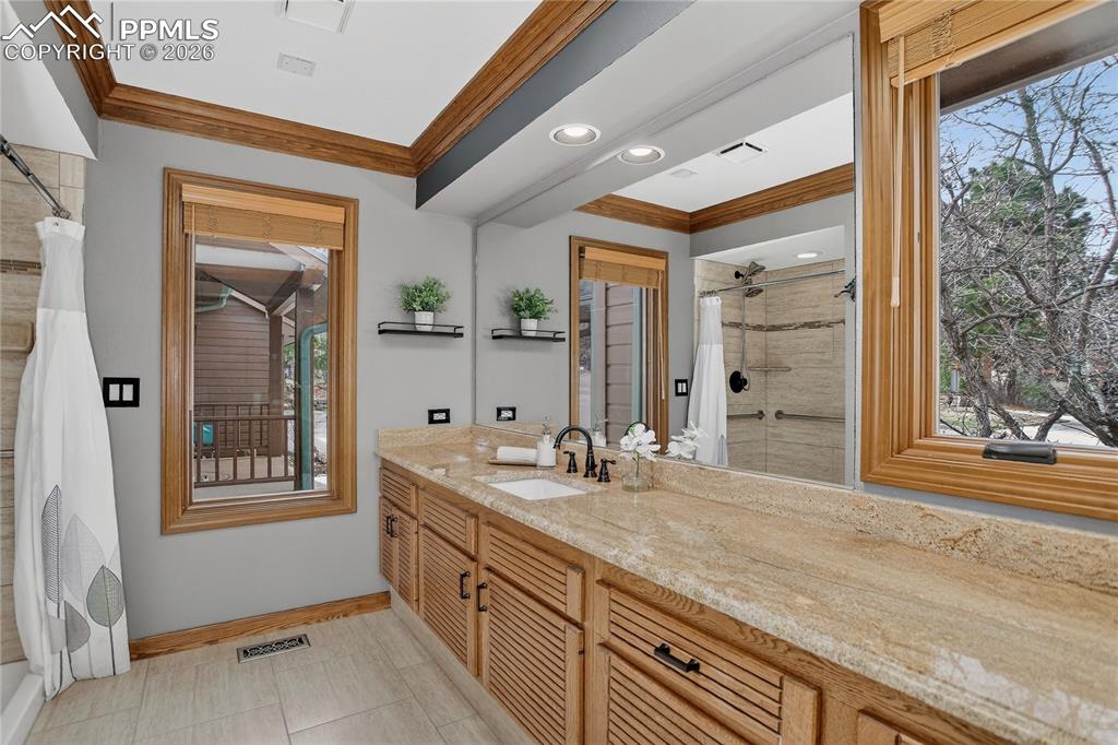 Image 22 of 42: Bathroom with crown molding & vanity