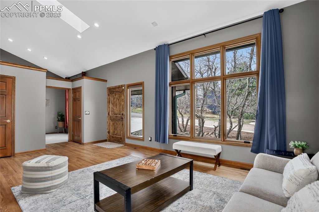 Image 3 of 42: Living area with a skylight, wood finished floors, and recessed lighting