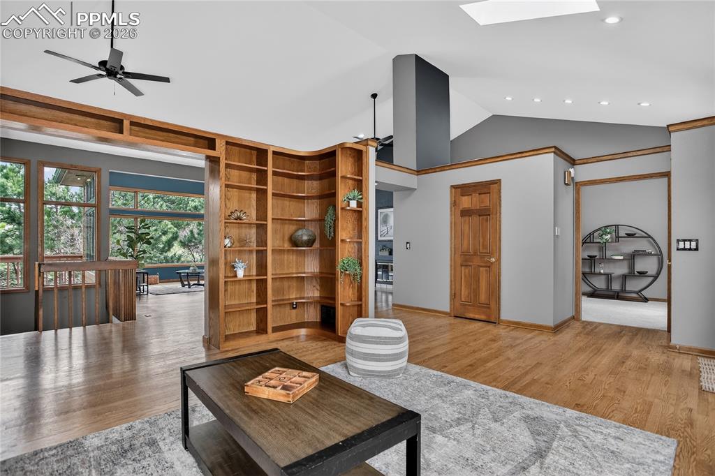Image 5 of 42: Living room featuring vaulted ceiling, wood finished floors, and ceiling fa