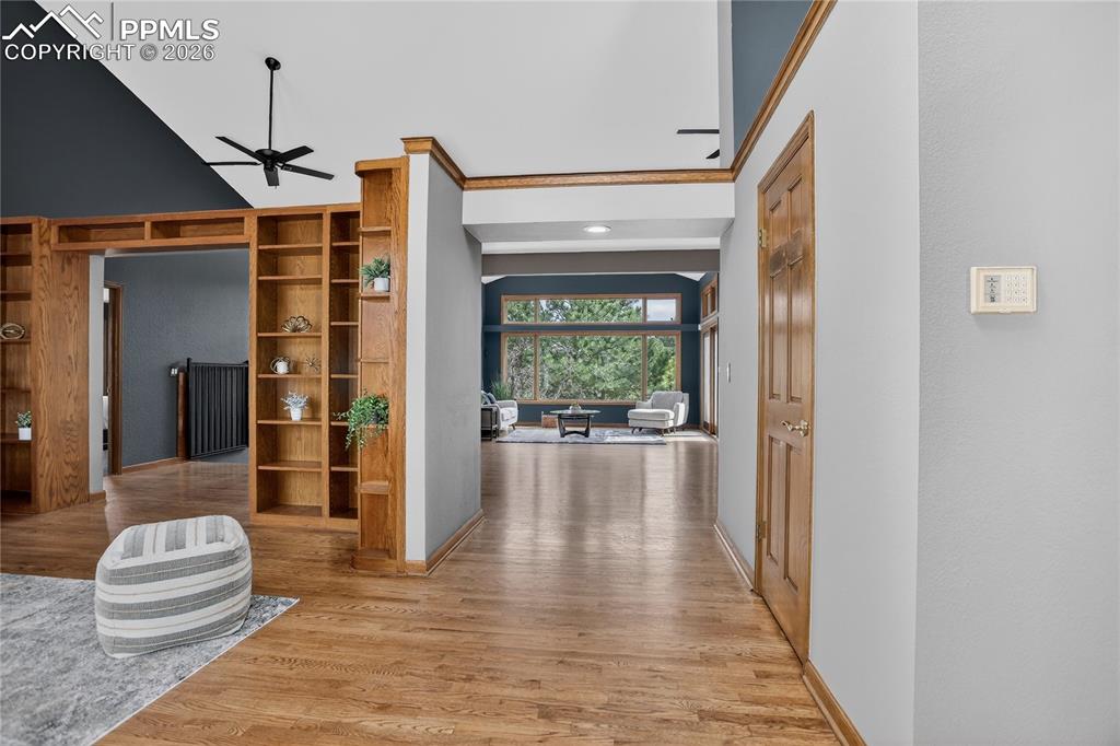 Image 6 of 42: Living room featuring ceiling fan, light wood-style floors, and ornamental 