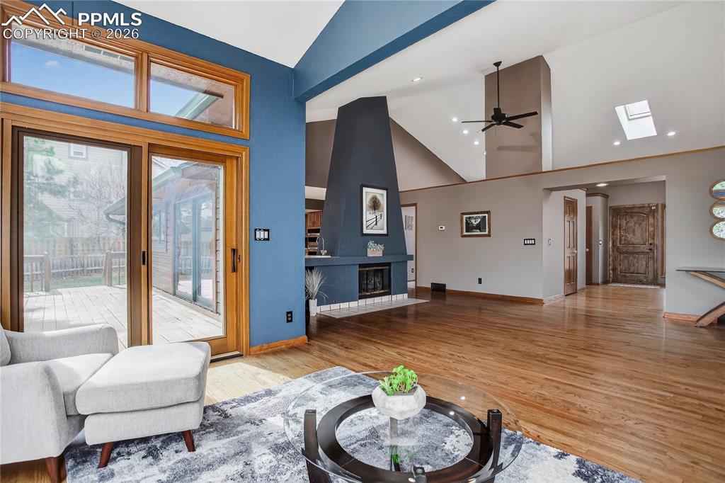 Image 9 of 42: Living area with ceiling fan, track lighting, wood finished floors, and hig