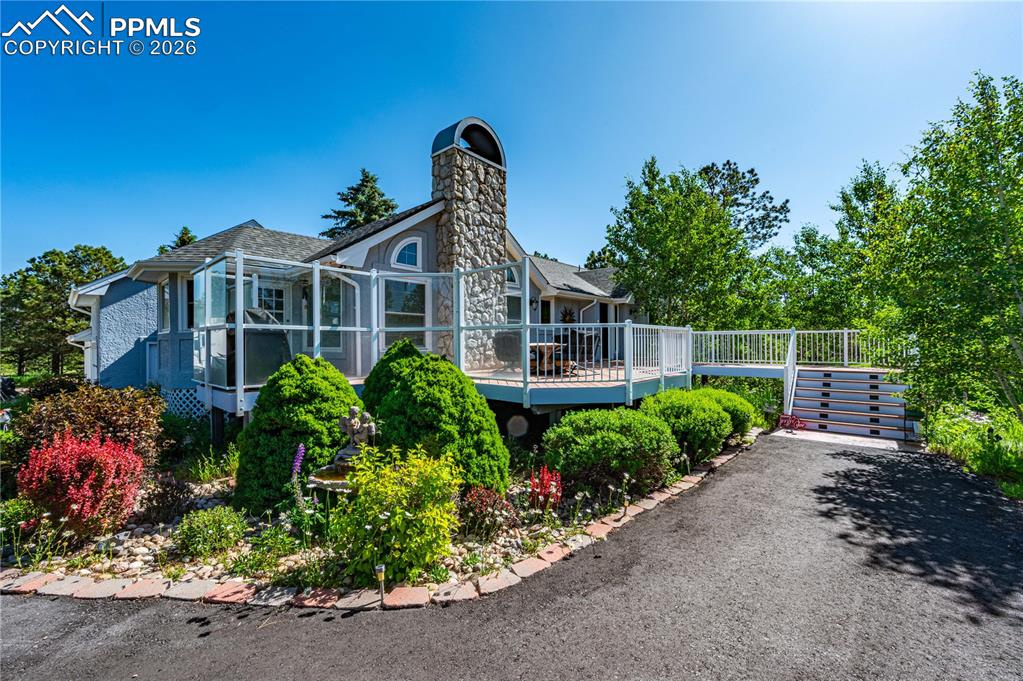 Caption: Beautifully landscaped front elevation with mature trees and inviting curb appeal.  