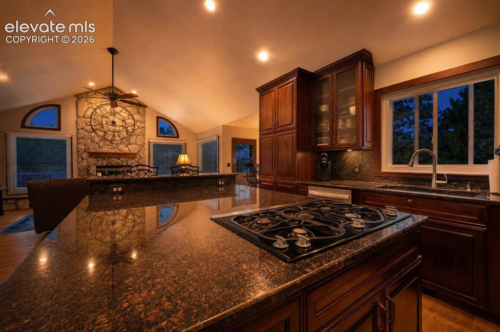 Image 14 of 50: Gourmet kitchen island with an integrated gas cooktop and natural stone cou