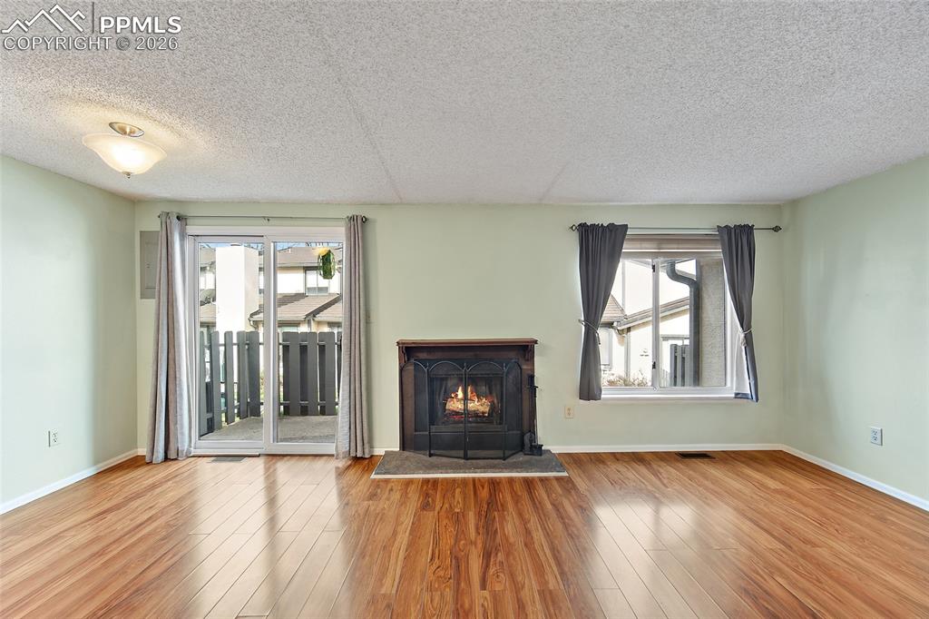 Image 20 of 31: Unfurnished living room featuring light wood-type flooring, a lit fireplace