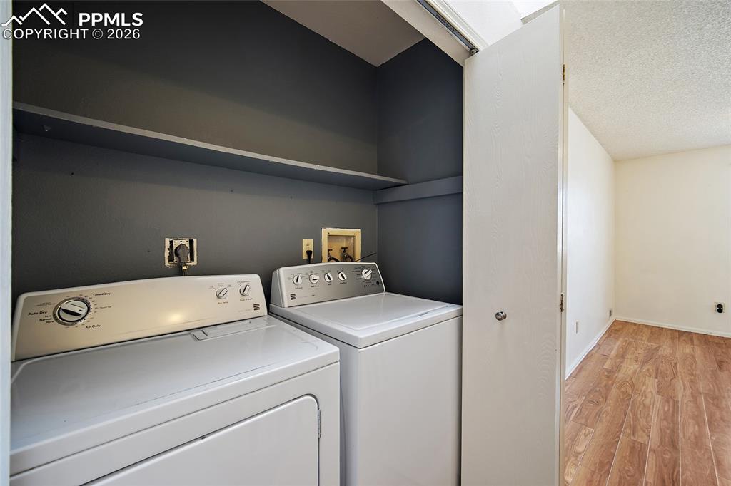 Image 21 of 31: Laundry area featuring light wood-style floors, washer and clothes dryer, a