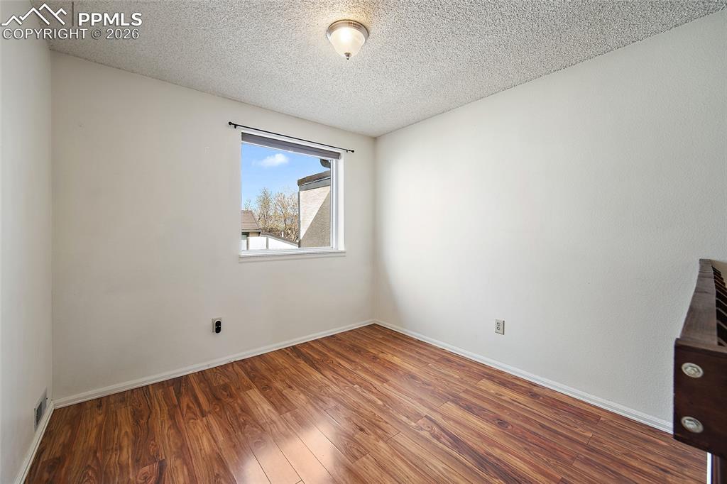 Image 24 of 31: Spare room with hardwood / wood-style flooring and a textured ceiling