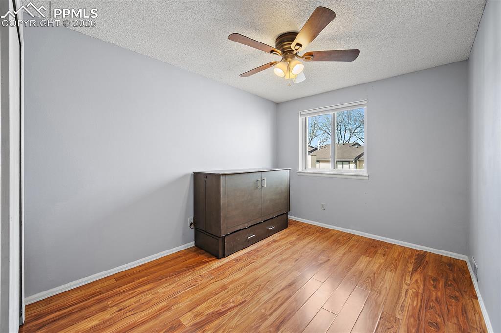 Image 25 of 31: Unfurnished bedroom featuring light wood-style flooring, ceiling fan, and a