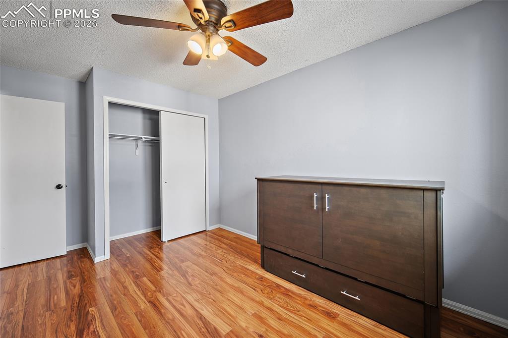 Image 26 of 31: Unfurnished bedroom featuring light wood-type flooring, a ceiling fan, a cl