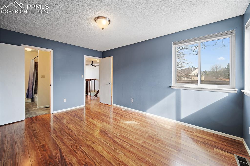Image 28 of 31: Unfurnished bedroom featuring light wood-style flooring and a textured ceil