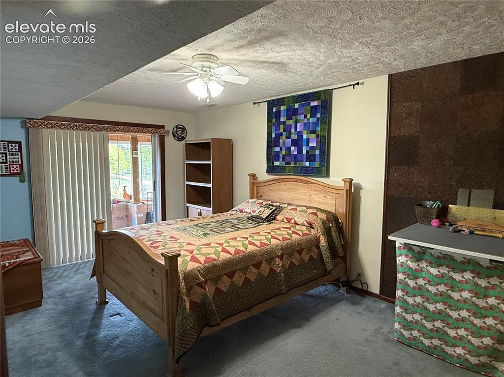 Image 14 of 38: Carpeted room featuring a ceiling fan with integrated lighting, a sliding g