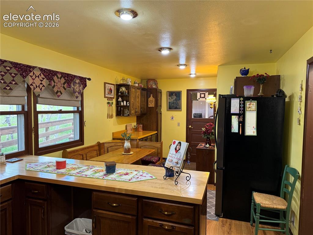 Image 9 of 38: Kitchen featuring wood-finish flooring, recessed ceiling lighting, and a bu