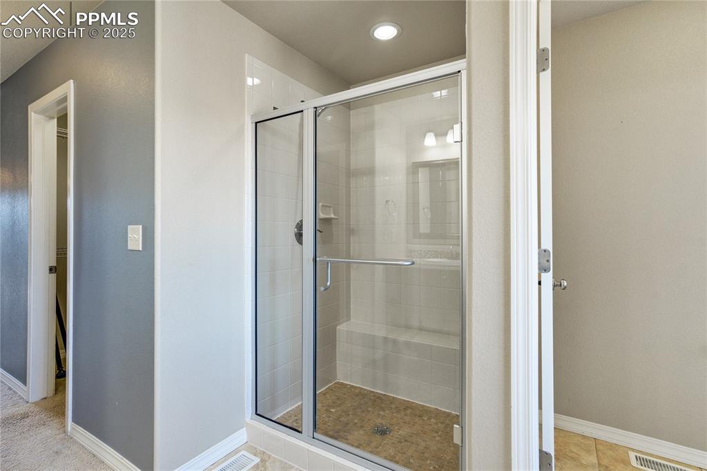 Image 24 of 50: Full bathroom with a stall shower and light tile patterned floors