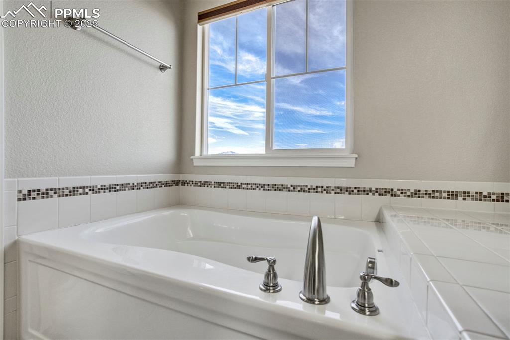 Image 25 of 50: Full bath featuring a bath and a textured wall