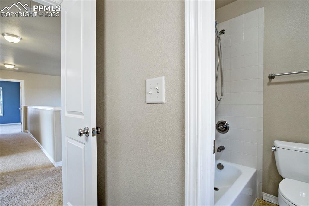 Image 28 of 50: Full bathroom featuring bathtub / shower combination and a textured wall