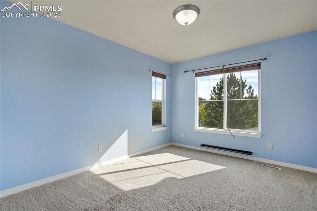 Image 29 of 50: Carpeted spare room with baseboards and a baseboard heating unit