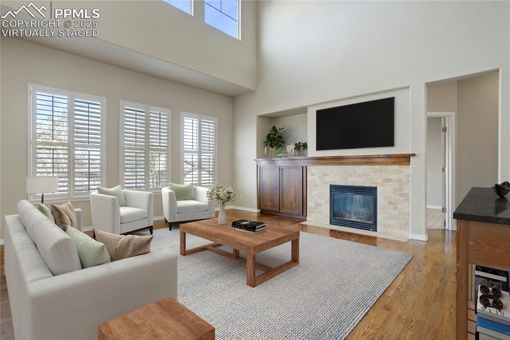 Image 3 of 50: Living area featuring healthy amount of natural light, a high ceiling, a ti