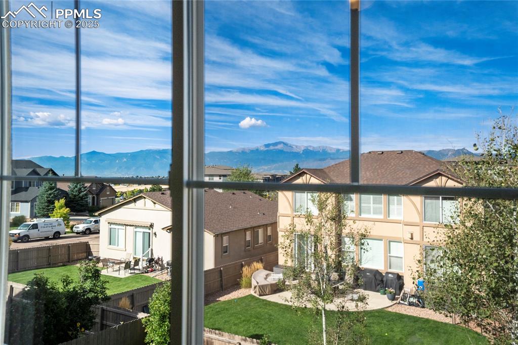 Image 31 of 50: Rear view of house with a mountain view, a balcony, and stucco siding