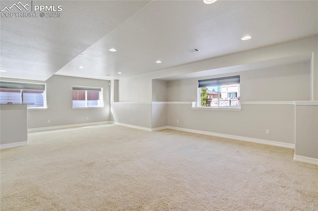 Image 35 of 50: Empty room featuring light carpet, recessed lighting, and a textured ceilin