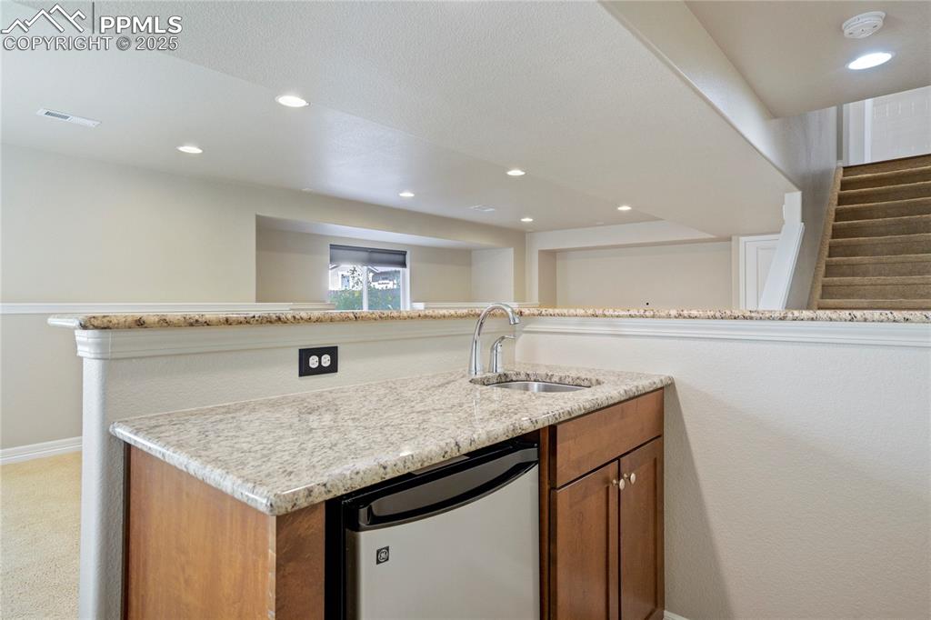 Image 36 of 50: Kitchen featuring brown cabinets, stainless steel dishwasher, recessed ligh