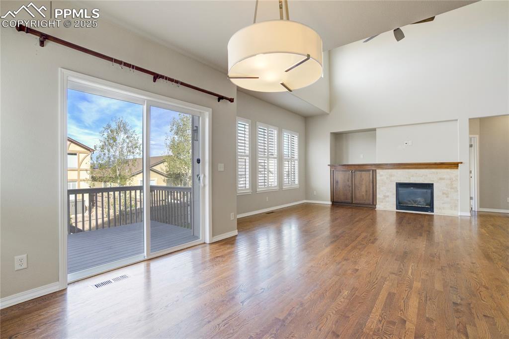 Image 50 of 50: Unfurnished living room with wood finished floors, a tile fireplace, and a 