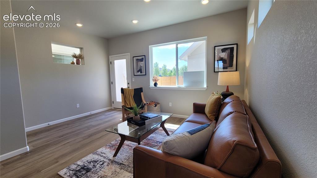 Image 13 of 41: Living room with LVP flooring, abundance of natural light, walk out to back