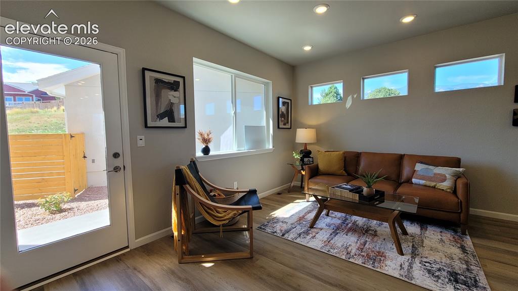 Image 14 of 41: Living room with LVP flooring, abundance of natural light, walk out to back