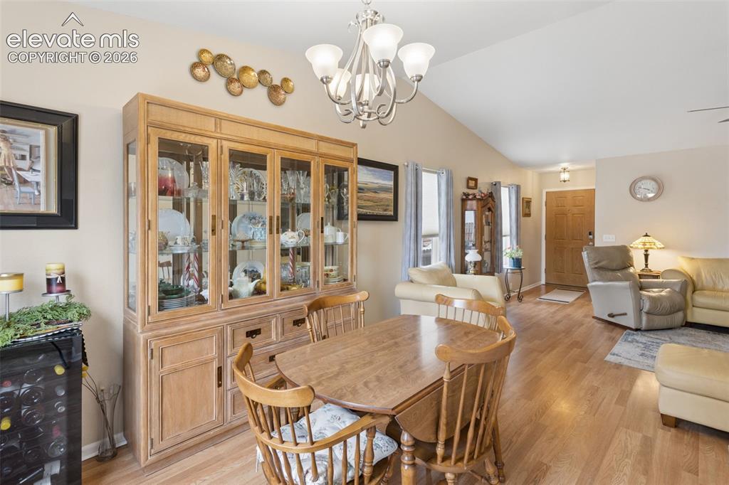 Image 10 of 32: Vaulted ceiling, wood-finish flooring, light tan wall color, built-in displ