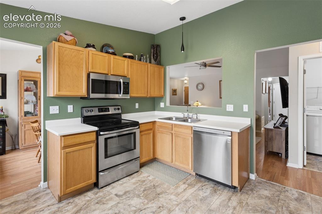 Image 12 of 32: Kitchen featuring wood-finish cabinetry, stainless steel appliances, white
