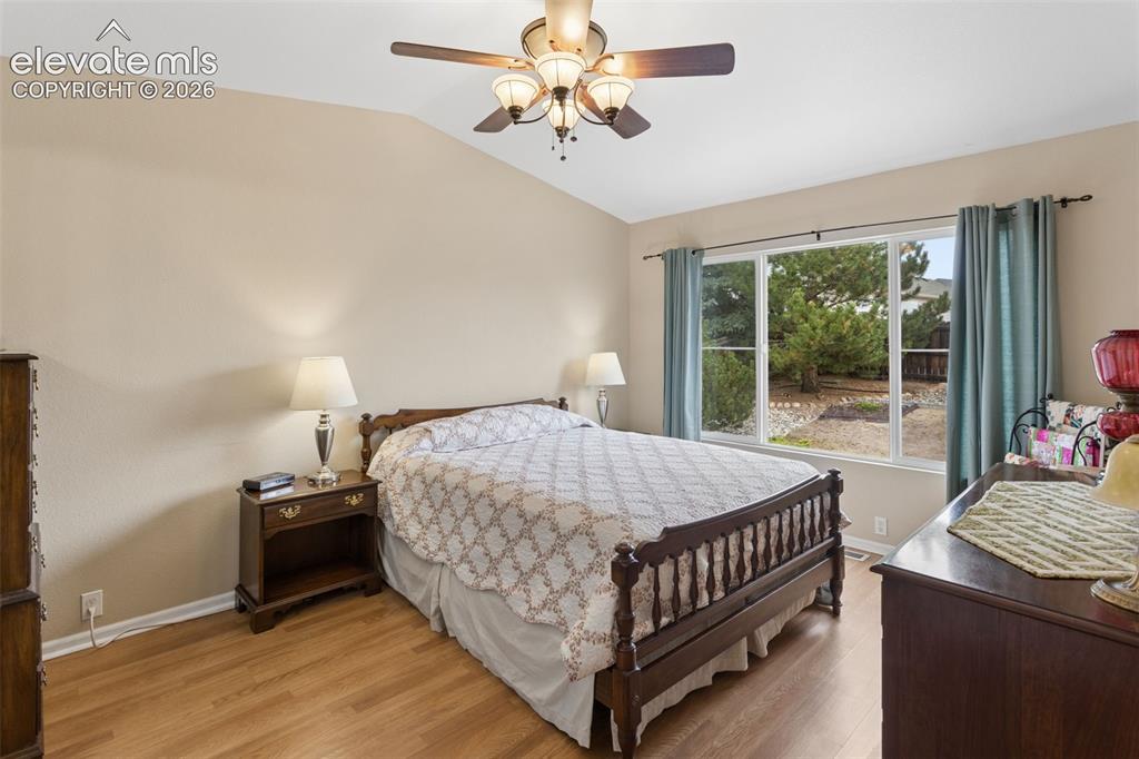 Image 14 of 32: Vaulted ceiling with a ceiling fan light fixture, wood-finish flooring, and