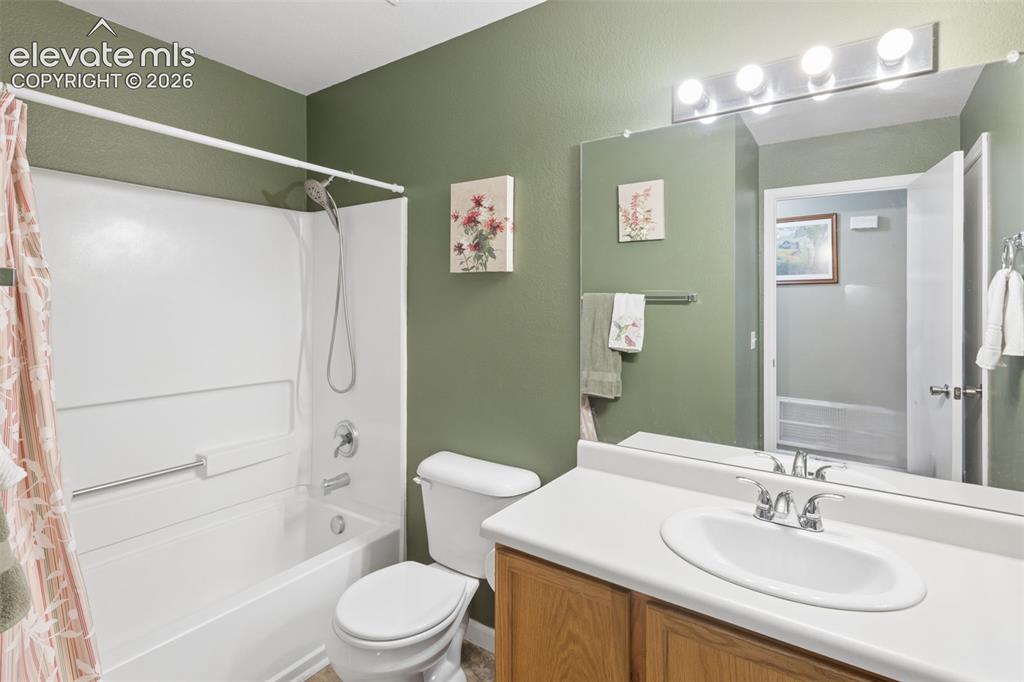 Image 19 of 32: Full bathroom featuring a single vanity with wood-finish cabinetry, a white