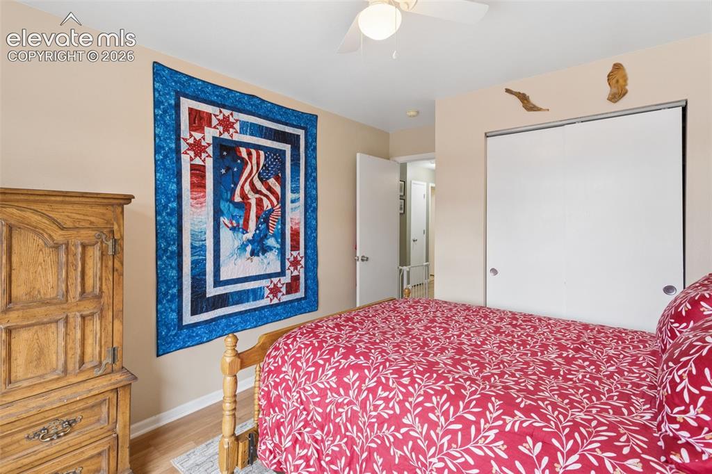 Image 21 of 32: Wood-finish flooring with a ceiling fan and a sliding closet door