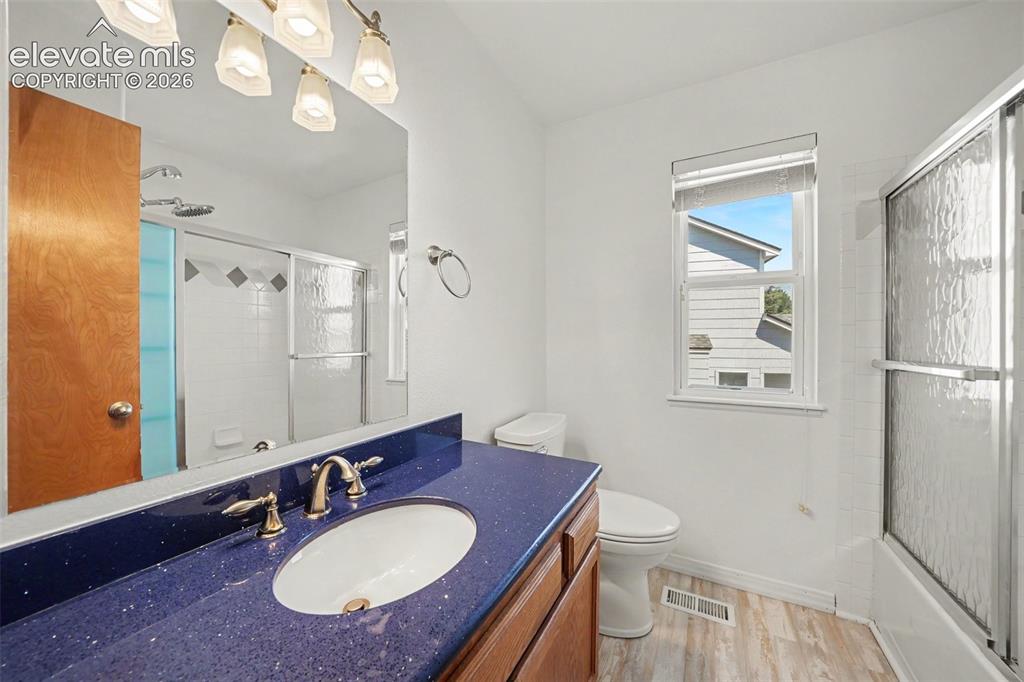 Image 14 of 23: Vanity with a speckled blue countertop and integrated sink, chrome-finish f